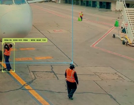 CoreX airside video intelligence demo: a public reference video of an apron with simulated detection boxes on a crew member and the nose of a parked aircraft